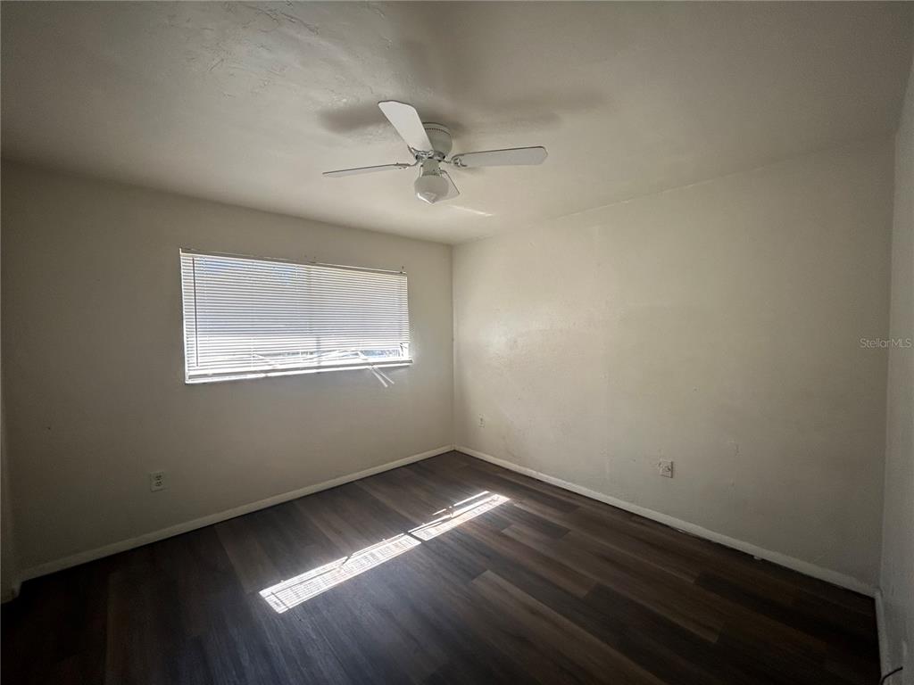 707 Southwest 68th Terrace, Unit A Gainesville, FL 32607 - Photo 11 of 16 an empty room with wooden floor and windows