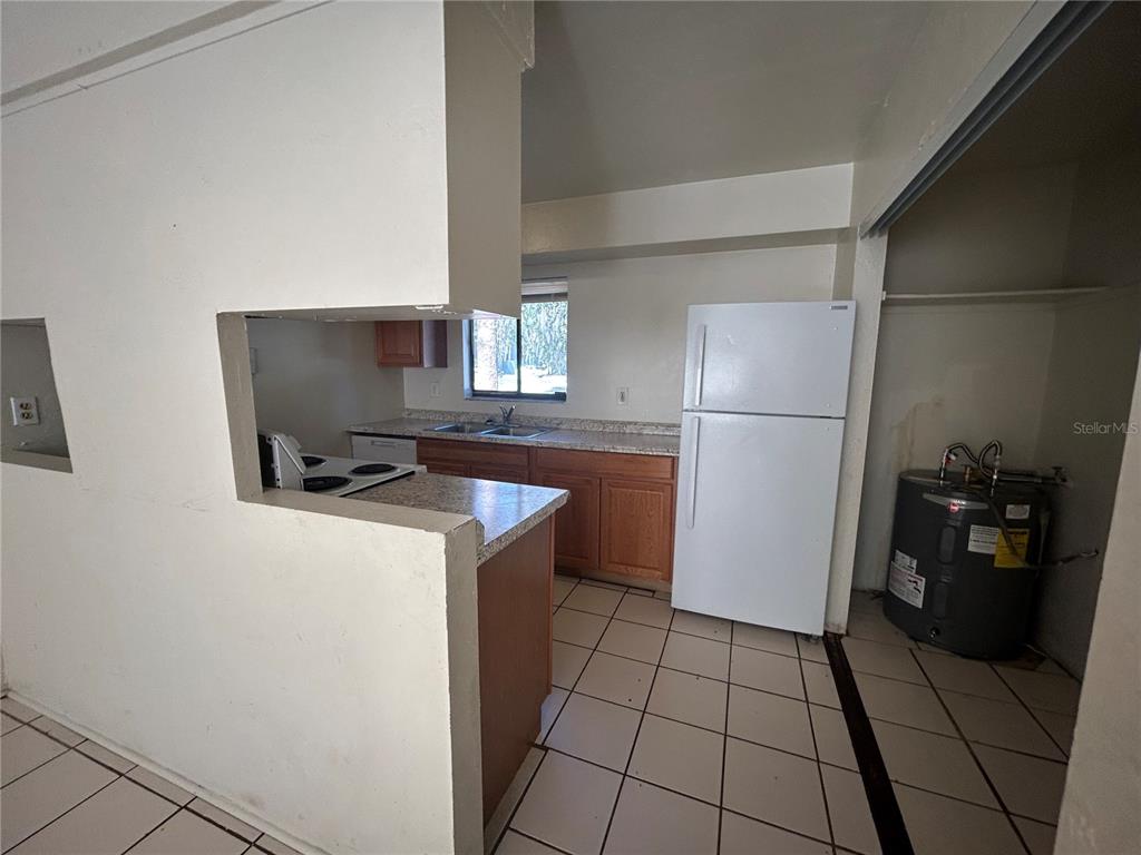 707 Southwest 68th Terrace, Unit A Gainesville, FL 32607 - Photo 5 of 16 a kitchen with a refrigerator and a stove