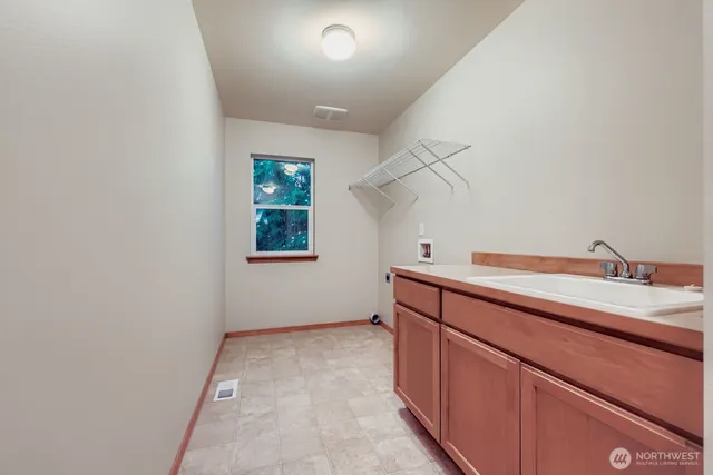 a room with a sink cabinets and utility