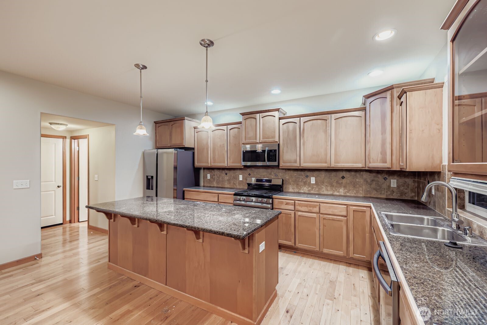 16305 37th Drive Southeast Bothell, WA 98012 - Photo 4 of 34 a kitchen with stainless steel appliances granite countertop a sink a stove and a wooden floors