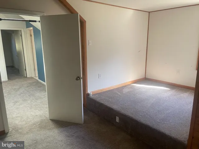 an empty room with windows and closet