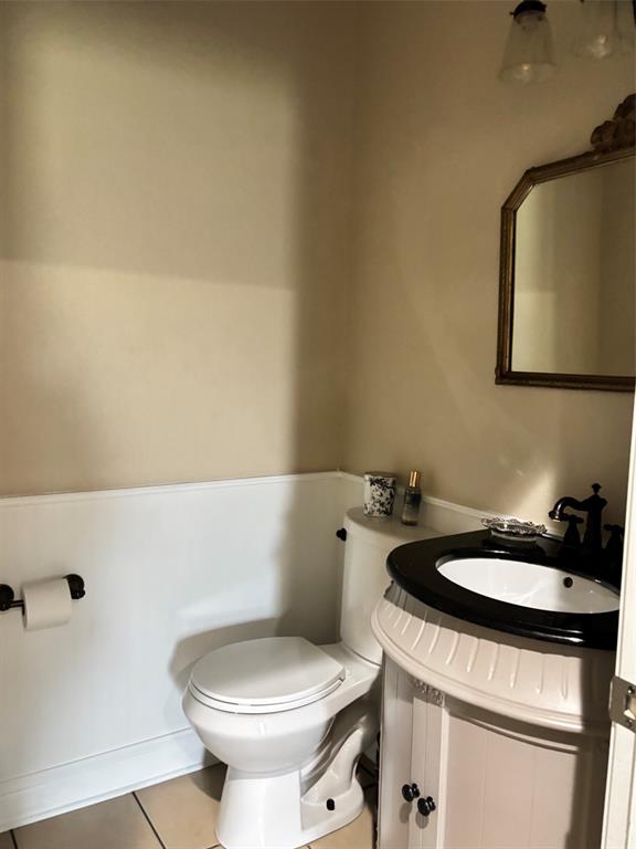 605 Jade Haughton, LA 71037 - Photo 11 of 34 Half bathroom featuring a white toilet, white wainscoting, and a light-colored vanity with a dark countertop and integrated sink