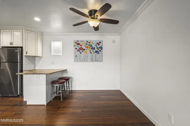 a view of kitchen with stainless steel appliances wooden floor and a refrigerator