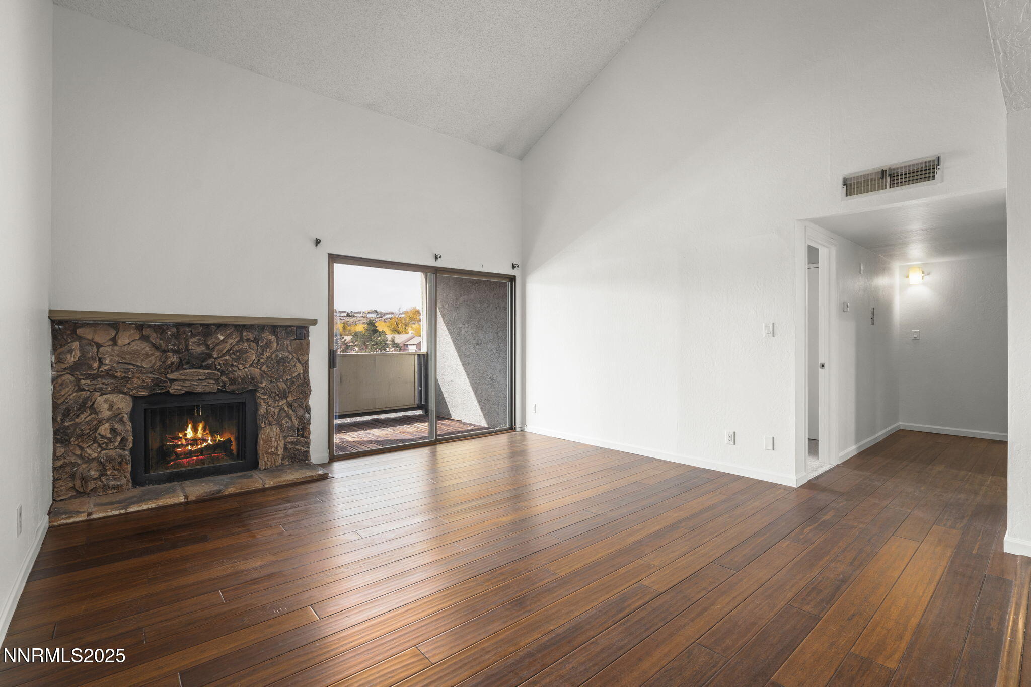 2845 Idlewild Drive, Unit 313 Reno, NV 89509 - Photo 21 of 27 a view of an empty room with wooden floor fireplace and a window
