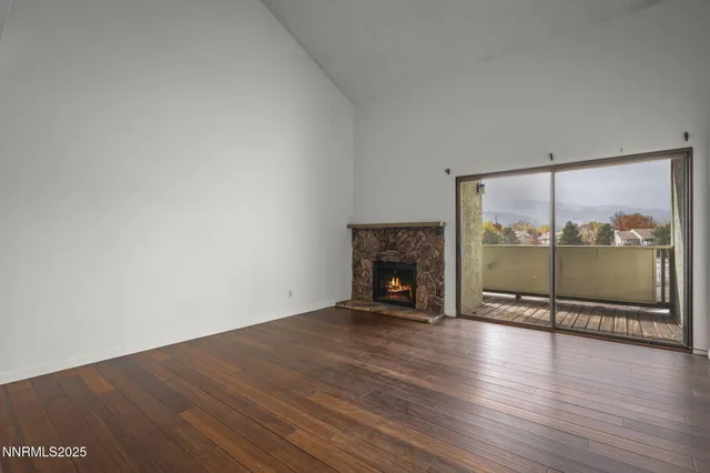 an empty room with wooden floor and fireplace