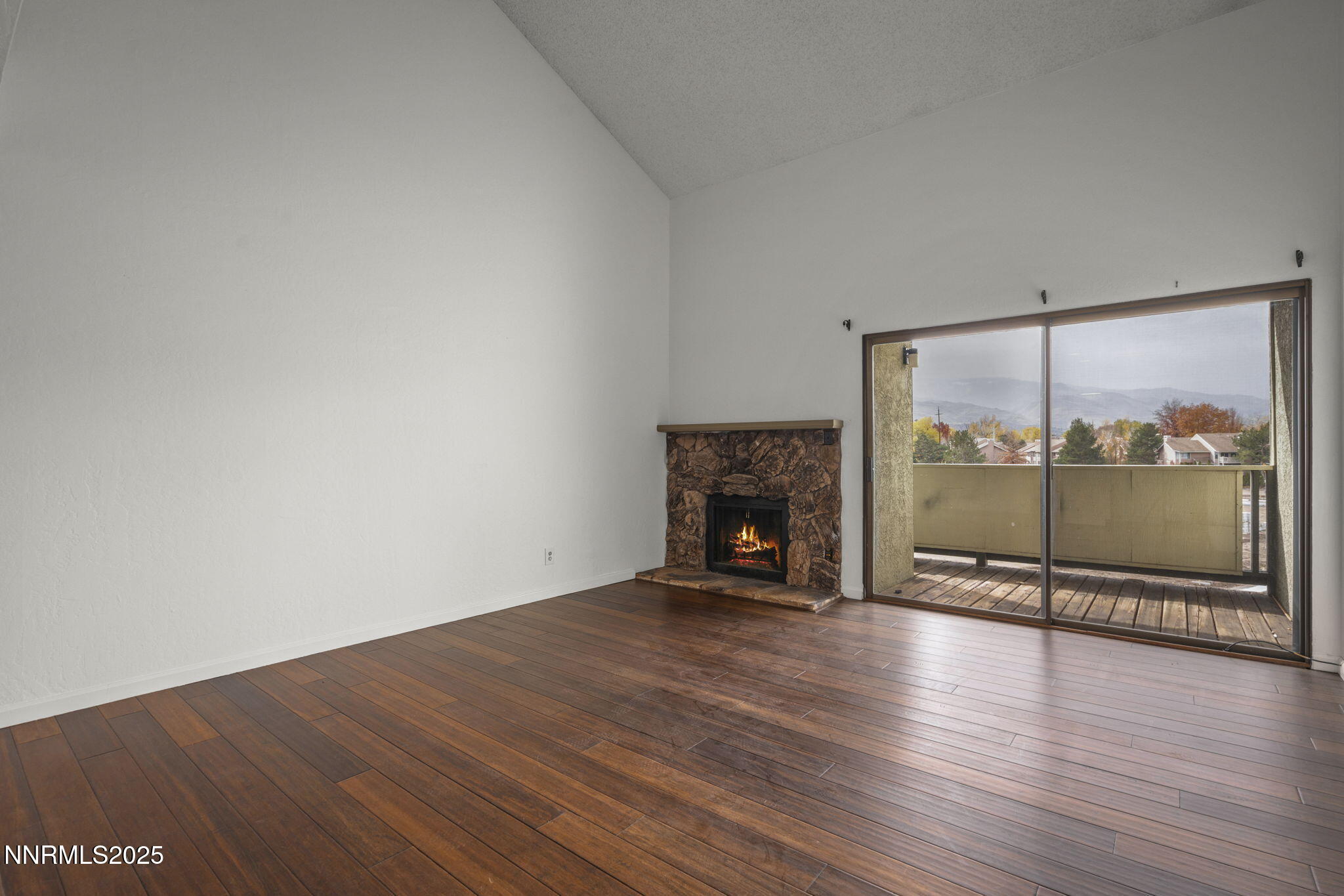 2845 Idlewild Drive, Unit 313 Reno, NV 89509 - Photo 22 of 27 an empty room with wooden floor and fireplace