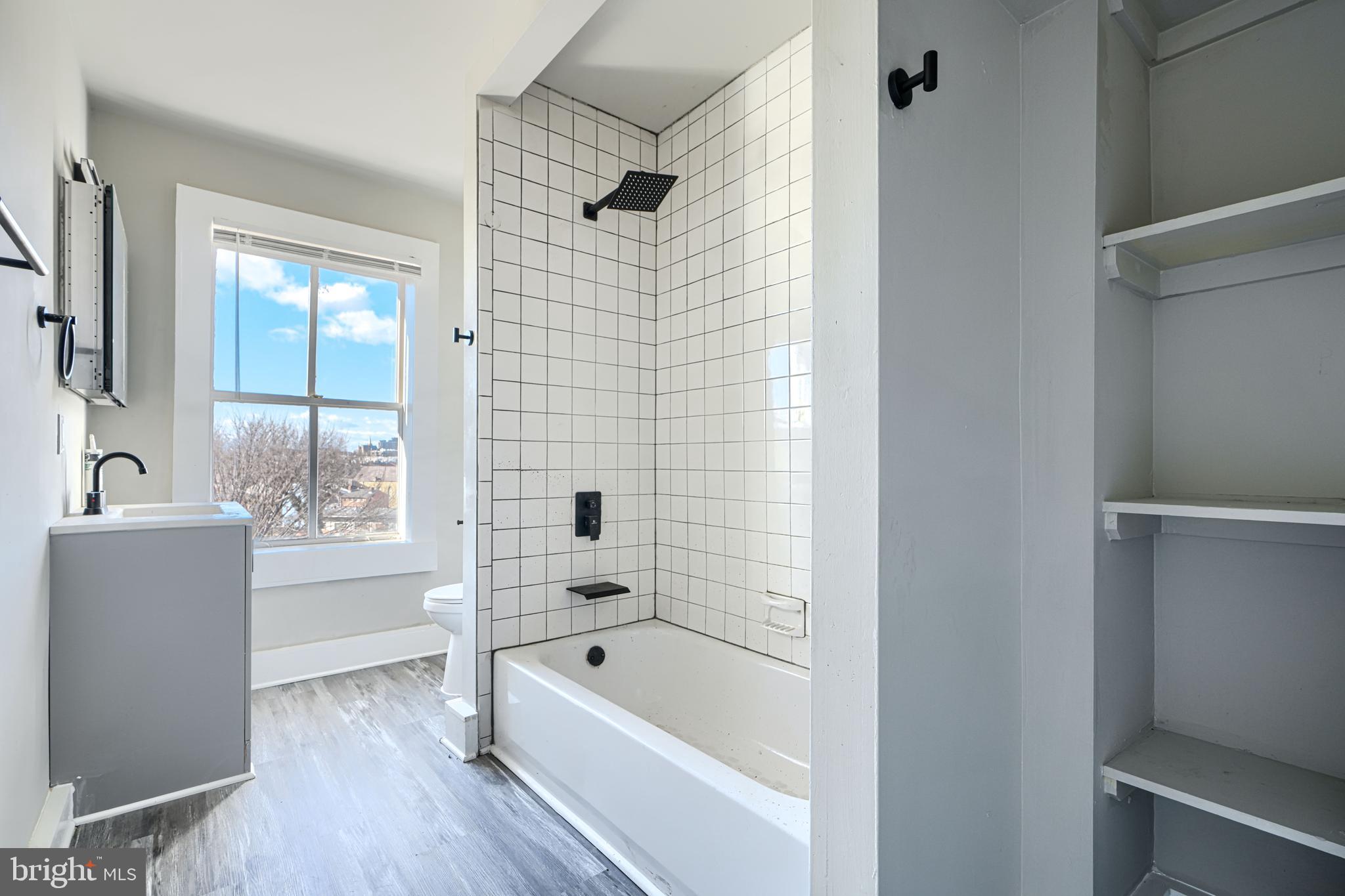 617 North Paca Street Baltimore, MD 21201 - Photo 16 of 20 a bathroom with a tub shower and a sink