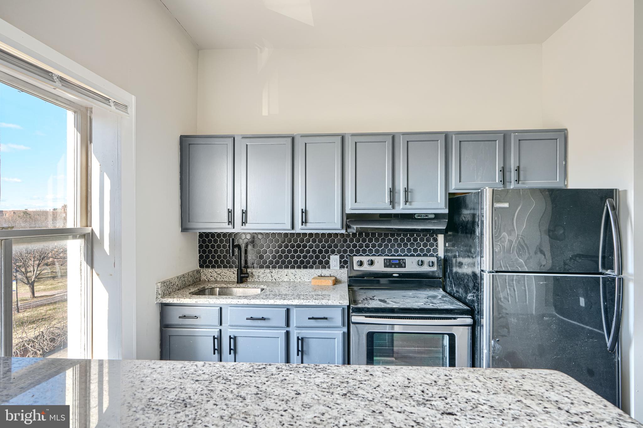617 North Paca Street Baltimore, MD 21201 - Photo 20 of 20 a kitchen with granite countertop a refrigerator stove and sink
