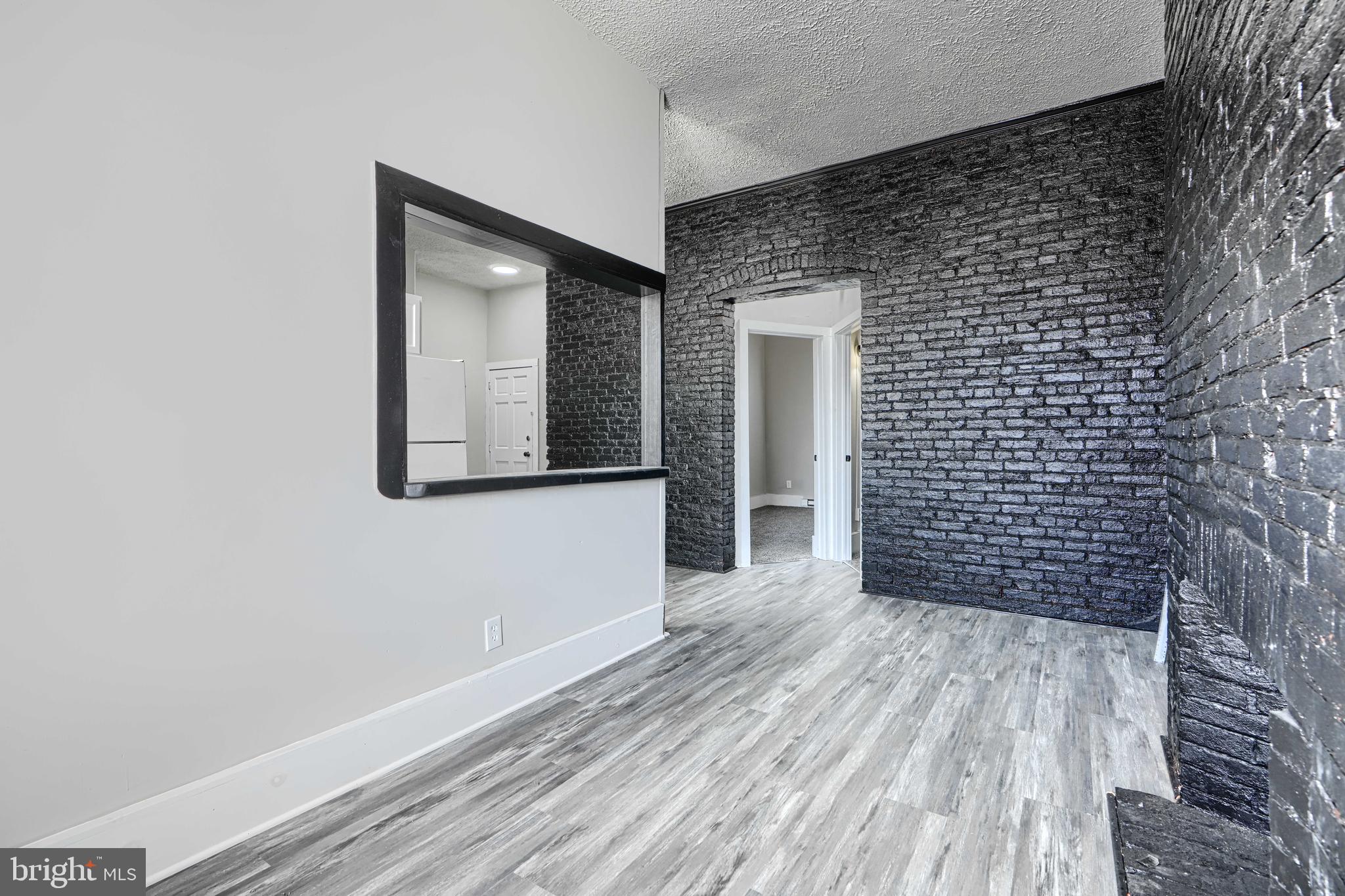 617 North Paca Street Baltimore, MD 21201 - Photo 6 of 20 a view of an empty room with wooden floor and a bathroom