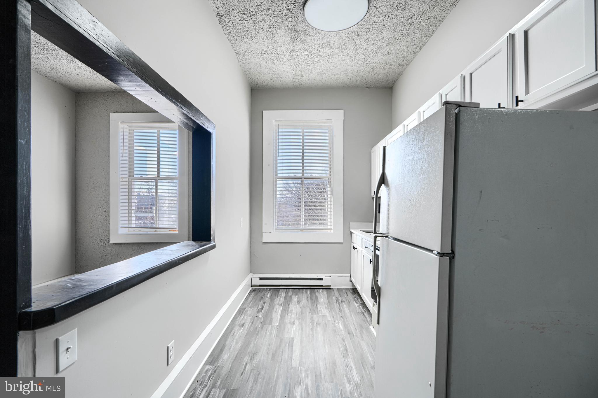 617 North Paca Street Baltimore, MD 21201 - Photo 9 of 20 a view of a kitchen with a fridge and wooden floor