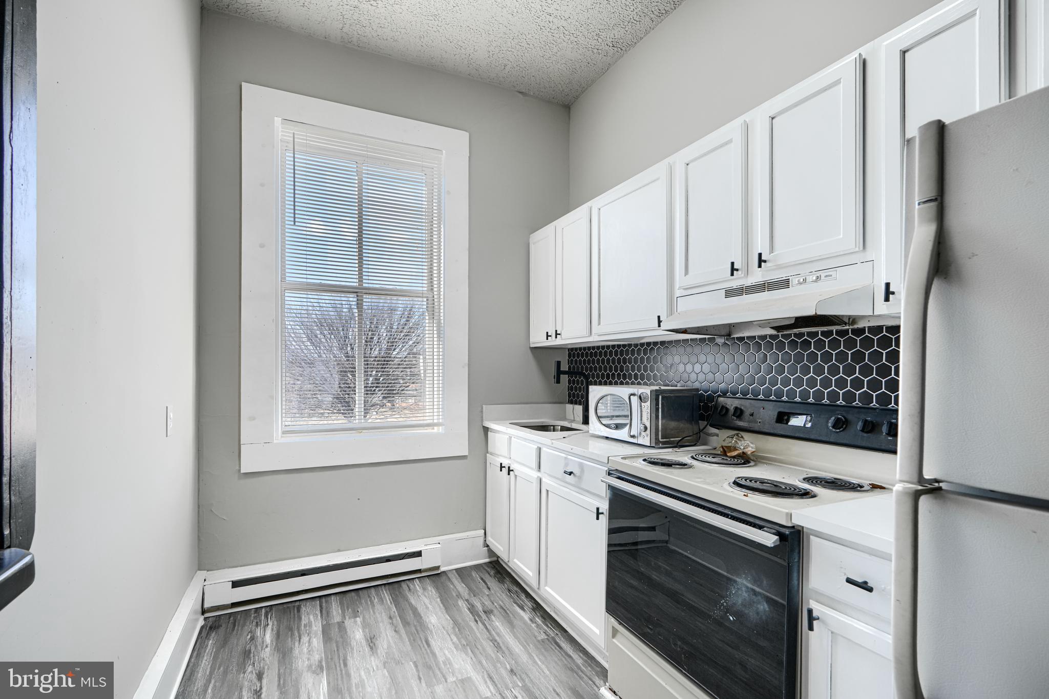 617 North Paca Street Baltimore, MD 21201 - Photo 10 of 20 a kitchen with white cabinets and white appliances