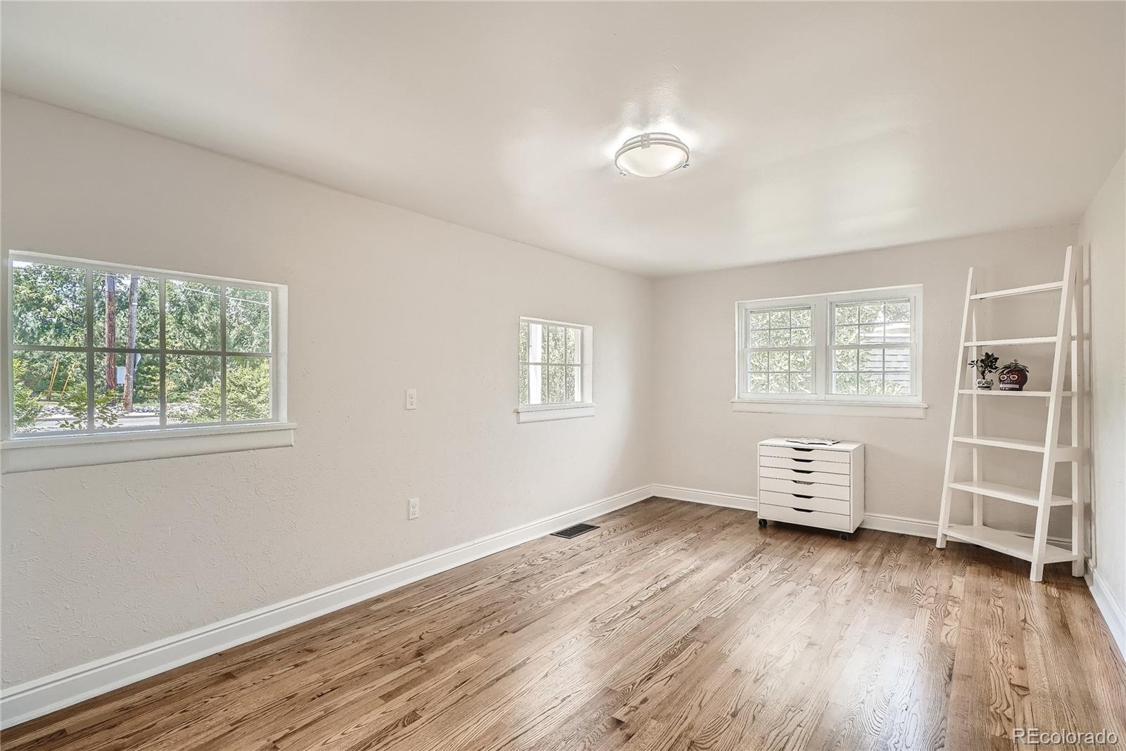 1209 West Ridge Road Littleton, CO 80120 - Photo 13 of 33 an empty room with wooden floor and window