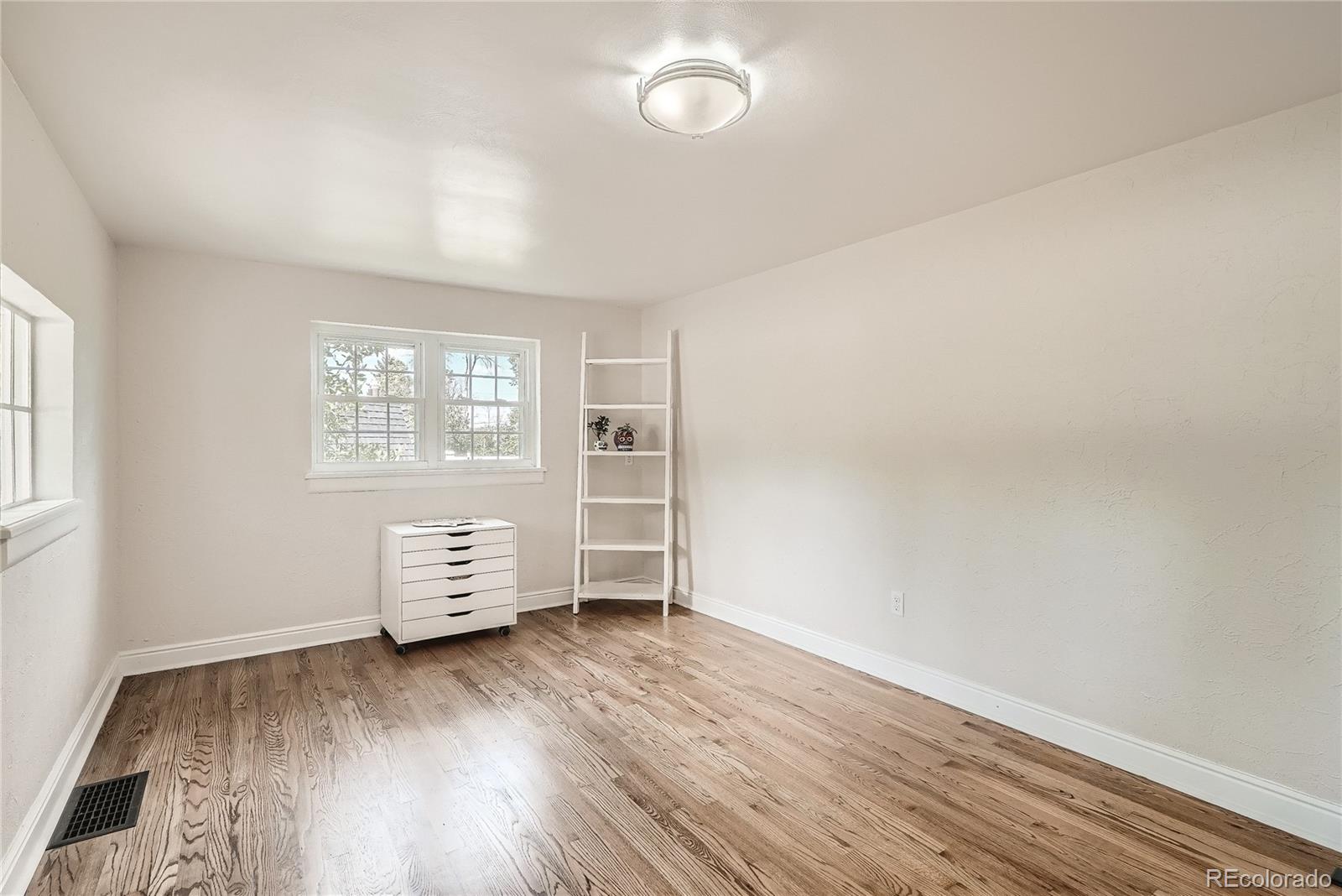 1209 West Ridge Road Littleton, CO 80120 - Photo 14 of 33 an empty room with wooden floor and windows