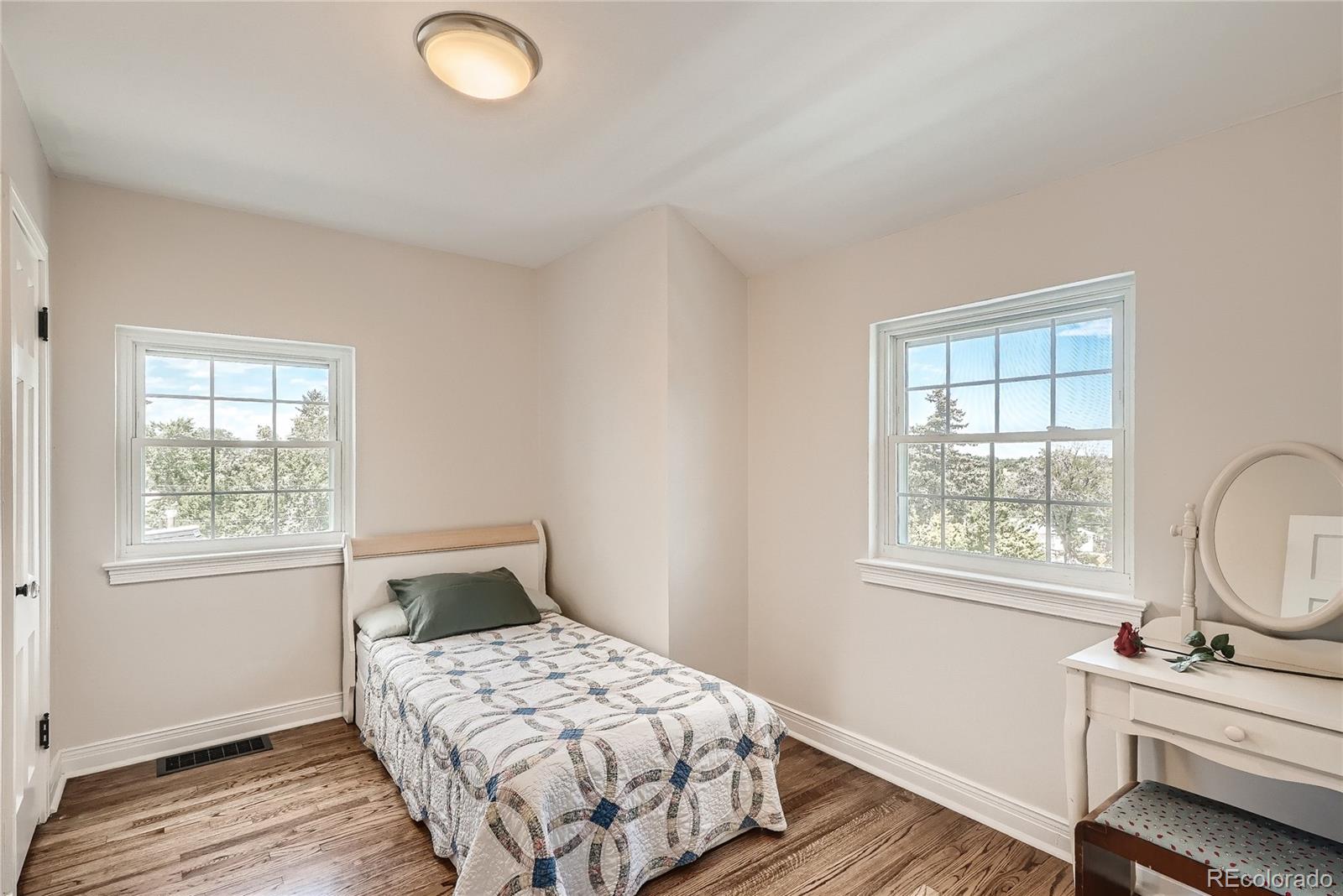 1209 West Ridge Road Littleton, CO 80120 - Photo 21 of 33 a bedroom with a bed and wooden floor