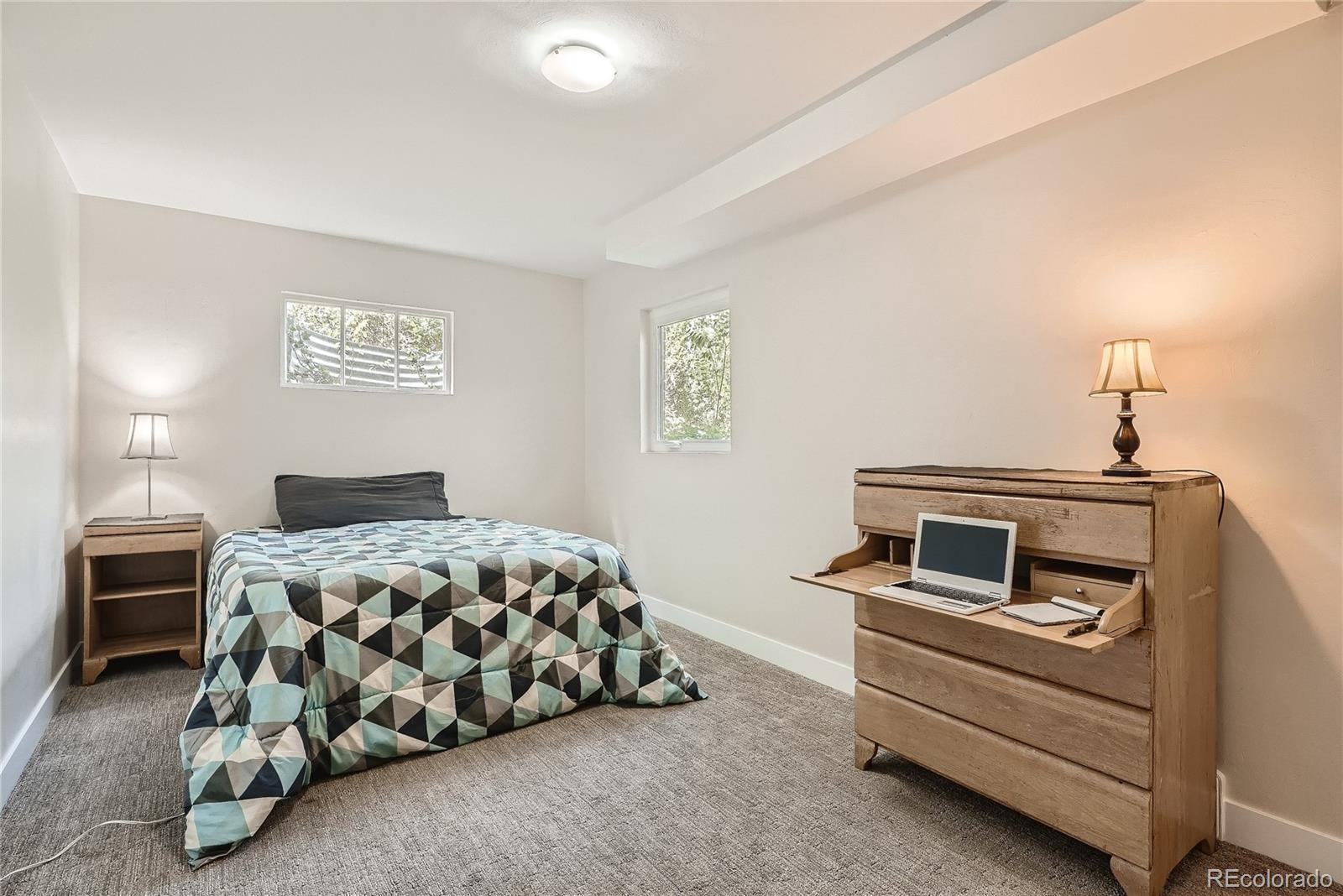 1209 West Ridge Road Littleton, CO 80120 - Photo 23 of 33 a bedroom with a bed and a lamp