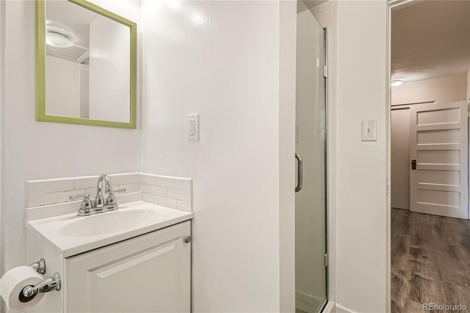 1209 West Ridge Road Littleton, CO 80120 - Photo 24 of 33 a bathroom with a sink vanity and a mirror
