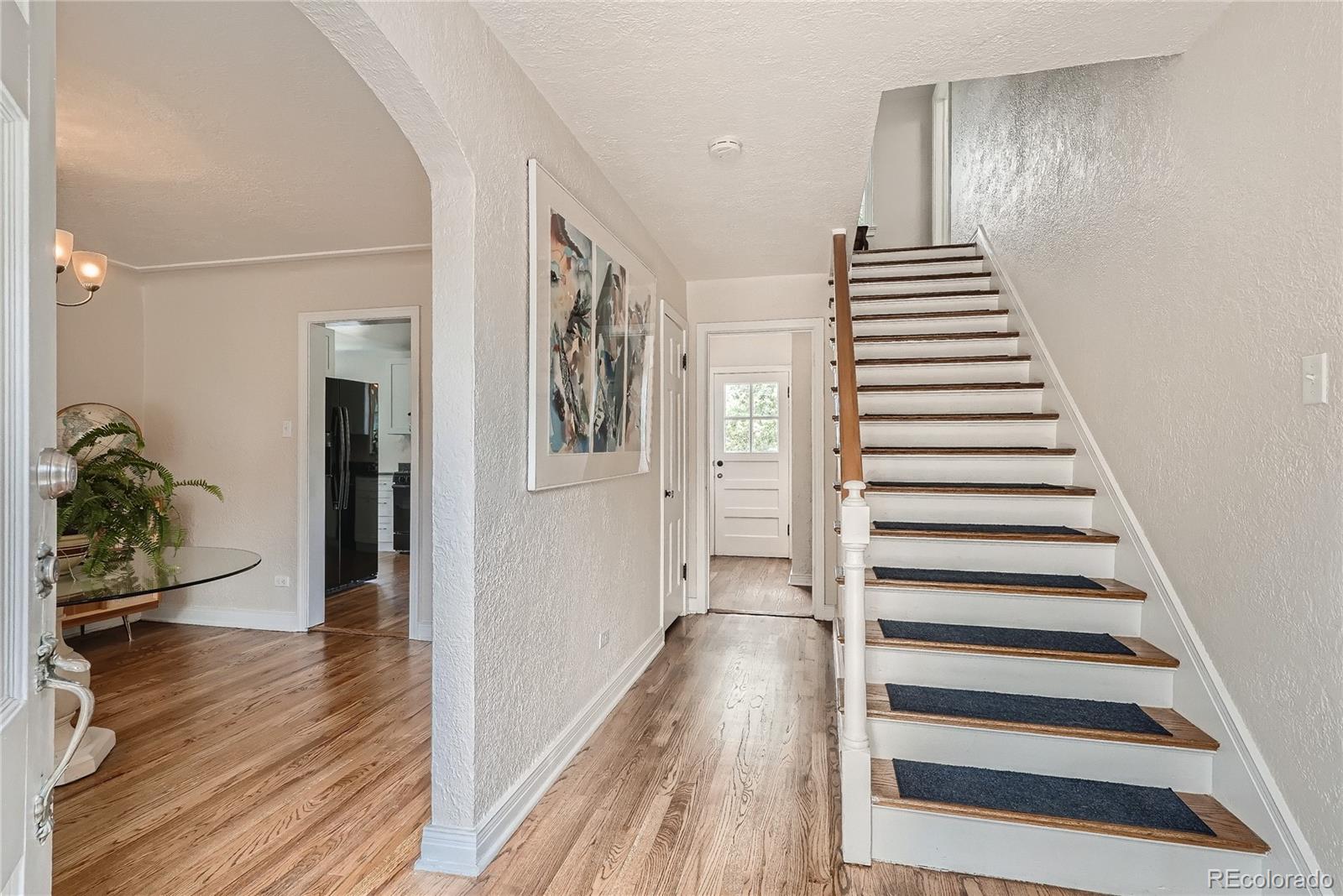 1209 West Ridge Road Littleton, CO 80120 - Photo 4 of 33 a view of a hallway with wooden floor and stairs