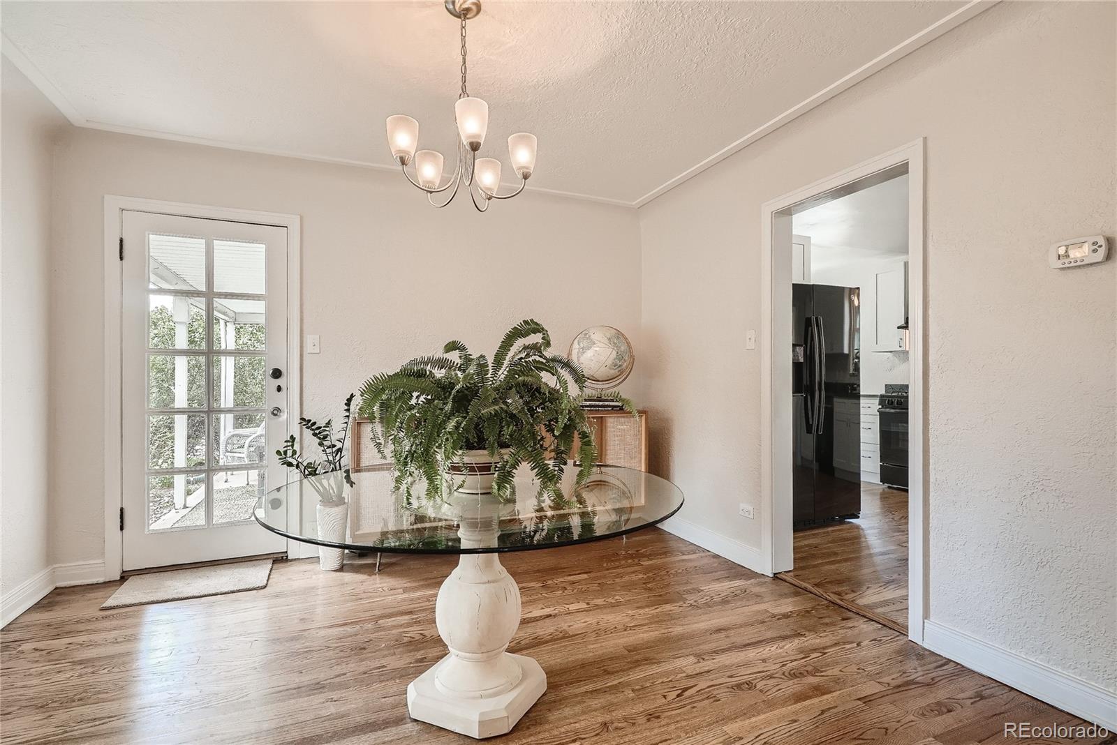 1209 West Ridge Road Littleton, CO 80120 - Photo 7 of 33 a view of a dining room with wooden floor potted plant and windows