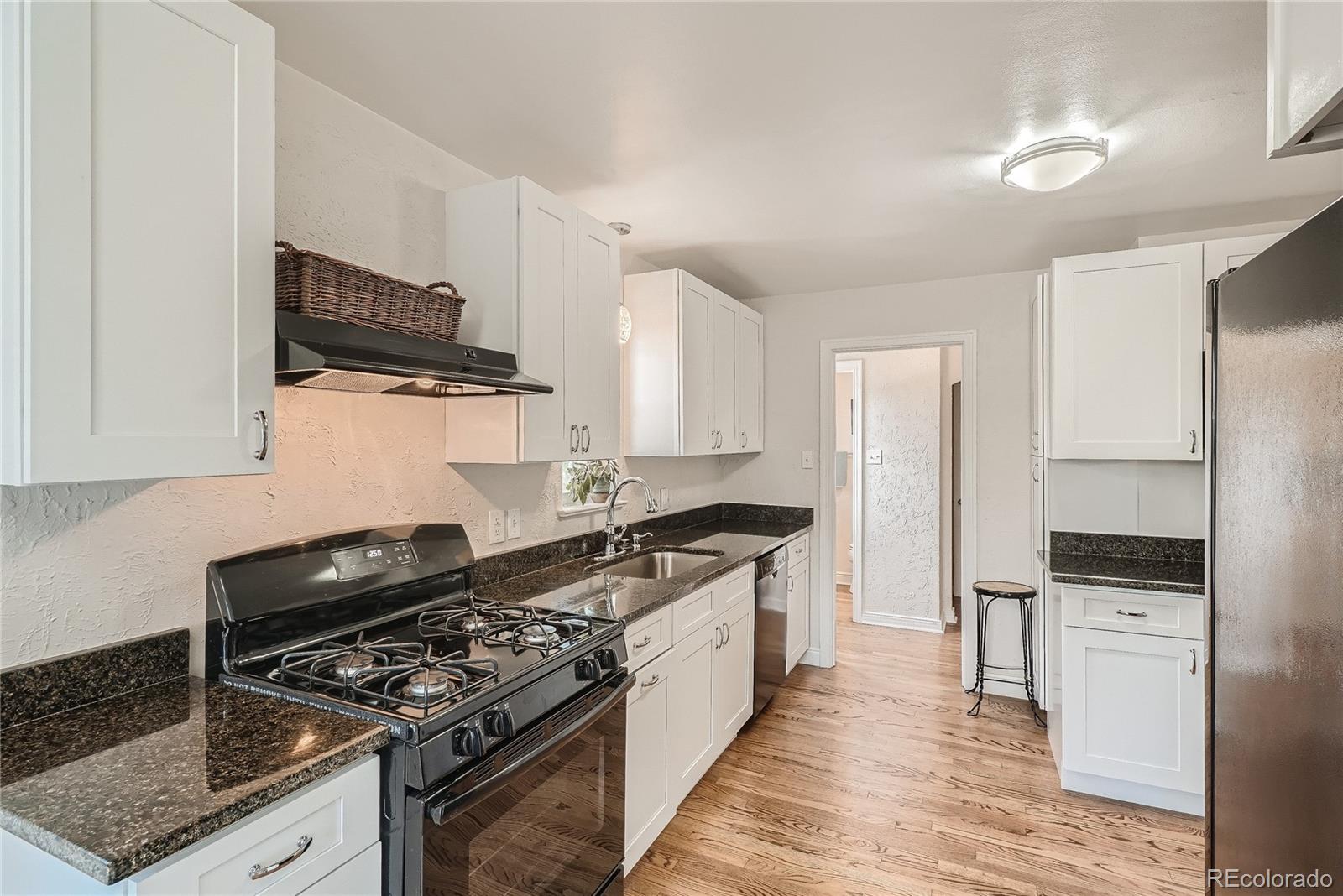 1209 West Ridge Road Littleton, CO 80120 - Photo 10 of 33 a kitchen with stainless steel appliances granite countertop a stove and a refrigerator