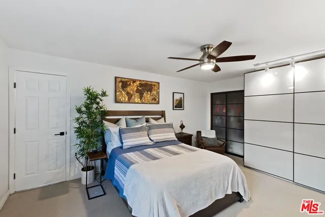 a bedroom with a large bed and a chandelier
