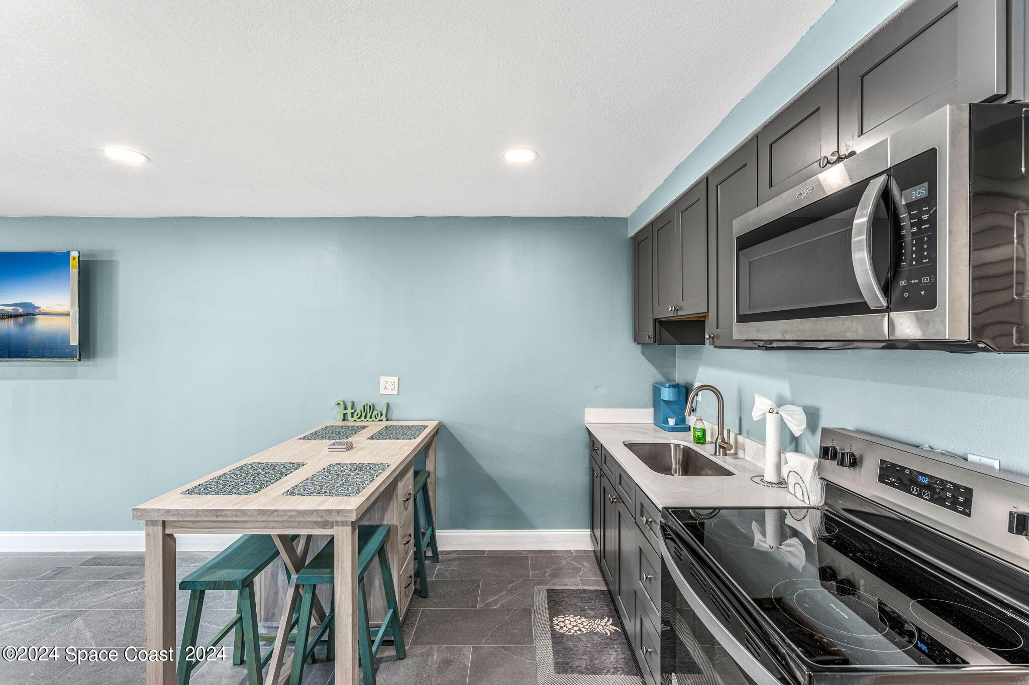 2189 Pineapple Avenue, Unit C Melbourne, FL 32935 - Photo 14 of 67 a kitchen with stainless steel appliances a stove a microwave a sink and cabinets