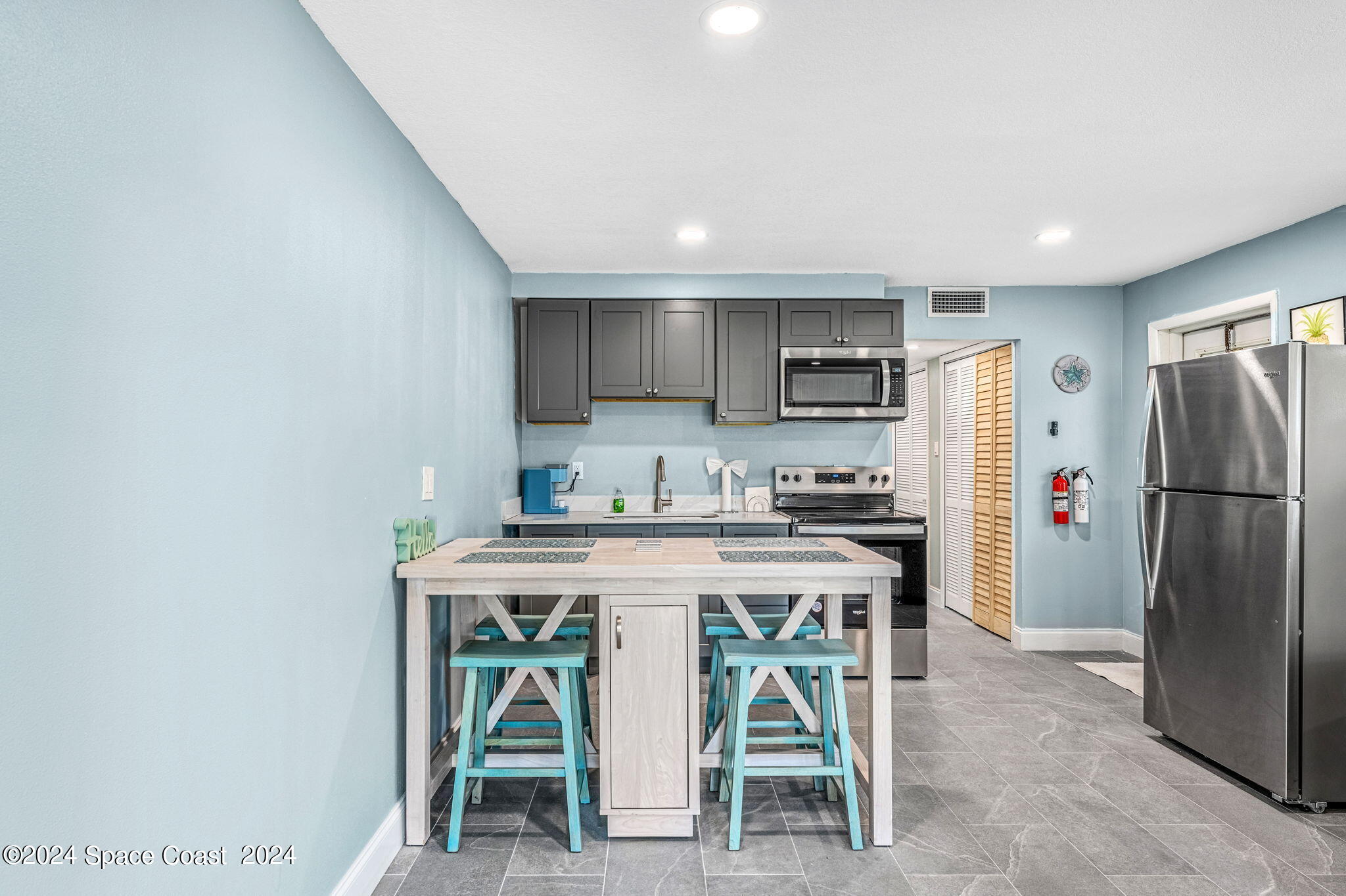 2189 Pineapple Avenue, Unit C Melbourne, FL 32935 - Photo 16 of 67 a kitchen with stainless steel appliances granite countertop a stove a refrigerator and a dining table