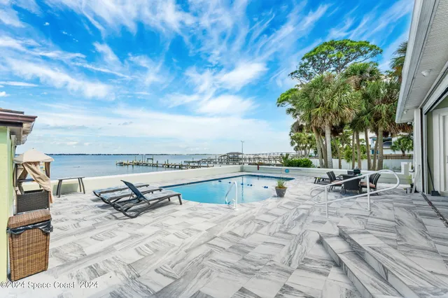 an aerial view of a residential houses with outdoor space and swimming pool