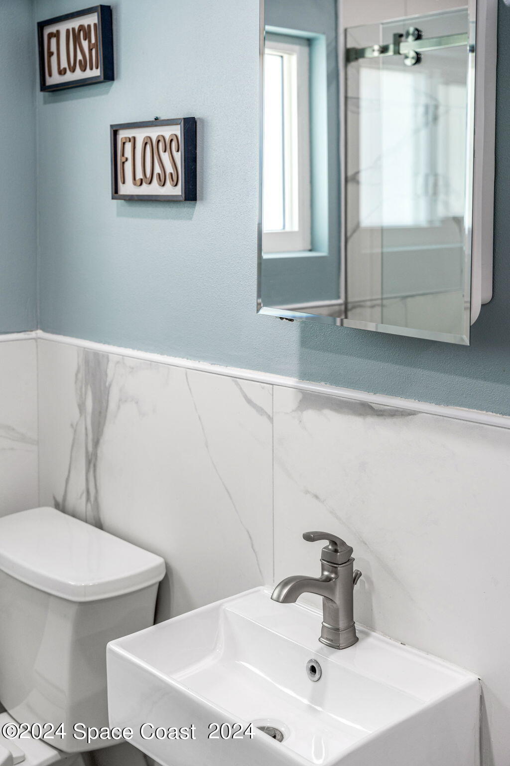 2189 Pineapple Avenue, Unit C Melbourne, FL 32935 - Photo 64 of 67 a bathroom with a toilet sink and mirror