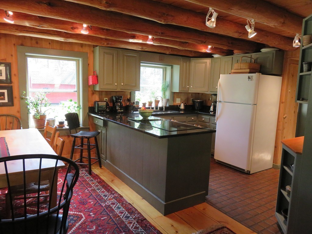 205 Linseed Road Hatfield, MA 01088 - Photo 4 of 30 a kitchen with wooden cabinets a refrigerator a stove a dining table and chairs with wooden floor