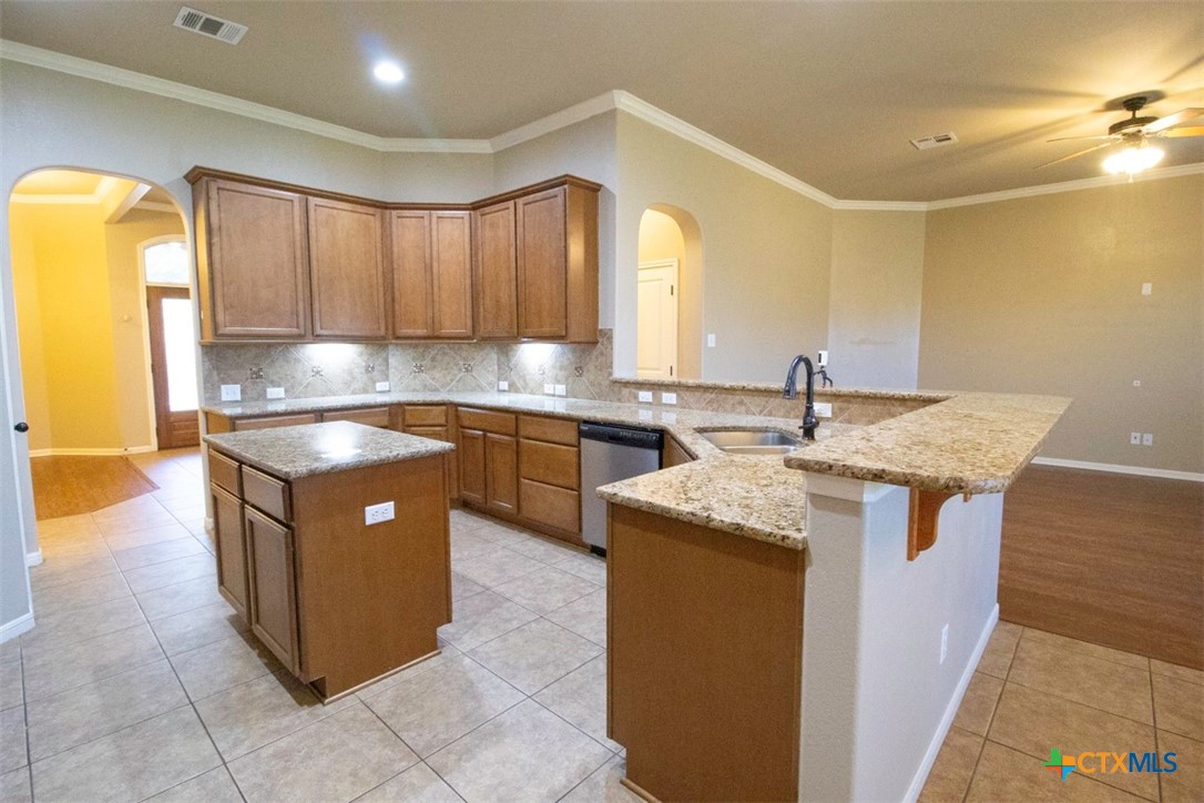 7022 Valley Mist Drive Temple, TX 76502 - Photo 13 of 36 a kitchen with kitchen island granite countertop a sink counter top space and cabinets
