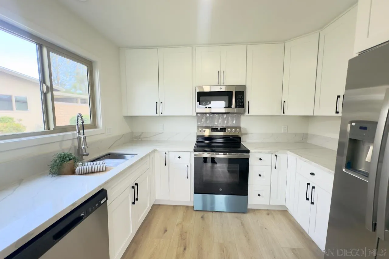 4529 Kittiwake Way Oceanside, CA 92057 - Photo 13 of 23 a kitchen with a sink a refrigerator and cabinets