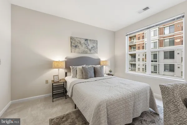 a bedroom with a bed and a large window