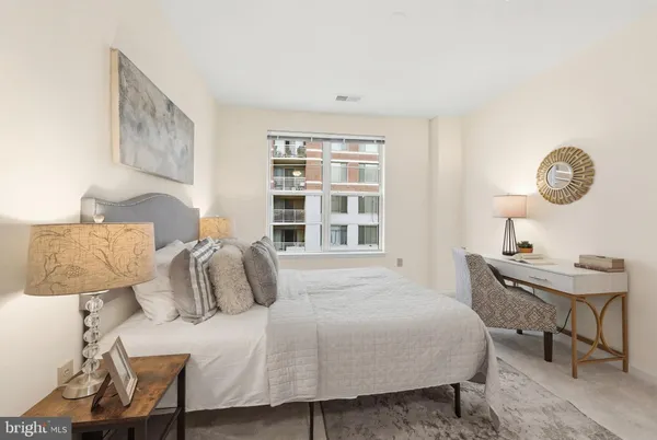 a bedroom with a bed a table and chair