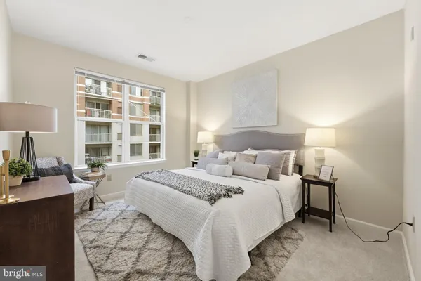 a bedroom with a bed and a lamp next to a window