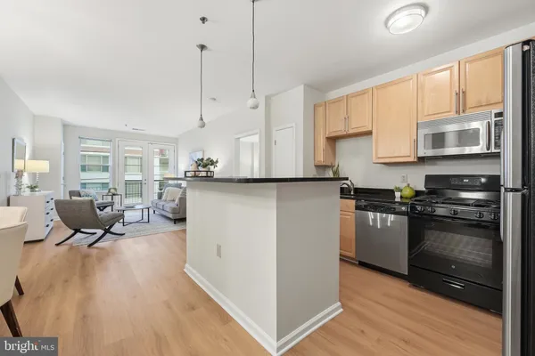 a kitchen with stainless steel appliances granite countertop a stove and a wooden floors
