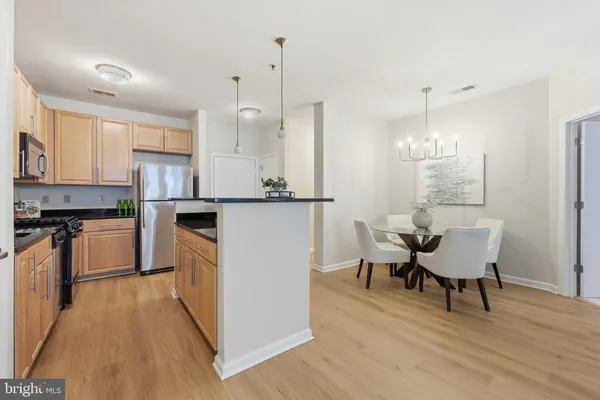 a kitchen with granite countertop white cabinets and stainless steel appliances