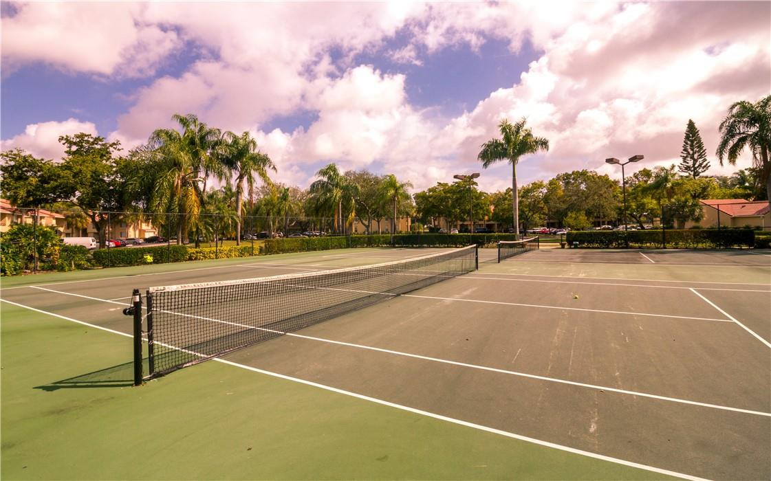 a view of a tennis court with lamp on the roadside