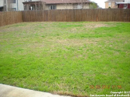 a view of a backyard with wooden fence