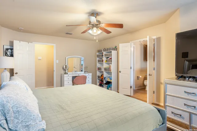 a bedroom with a bed and a flat tv screen on dresser