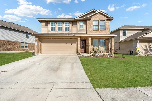a front view of a house with a yard and potted plants