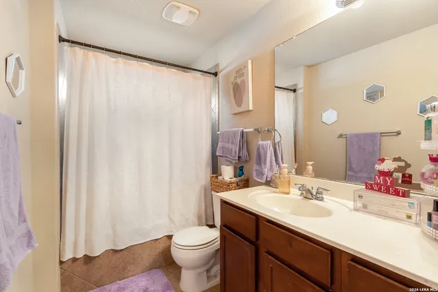 a bathroom with a double vanity sink toilet and a mirror