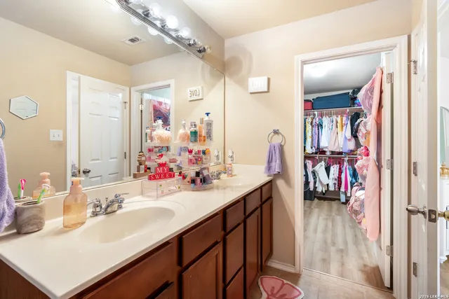 a en suite bathroom with a sink vanity and a mirror