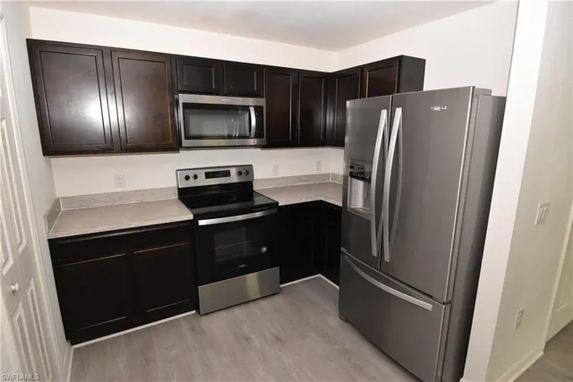 a kitchen with stainless steel appliances and refrigerator