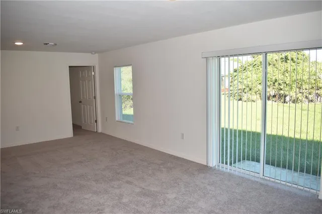 a view of a room with sliding door and tree in it
