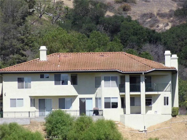 a view of a white house with large windows and a small yard
