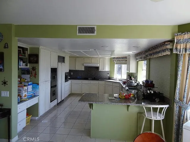 a kitchen with a sink dishwasher and a refrigerator