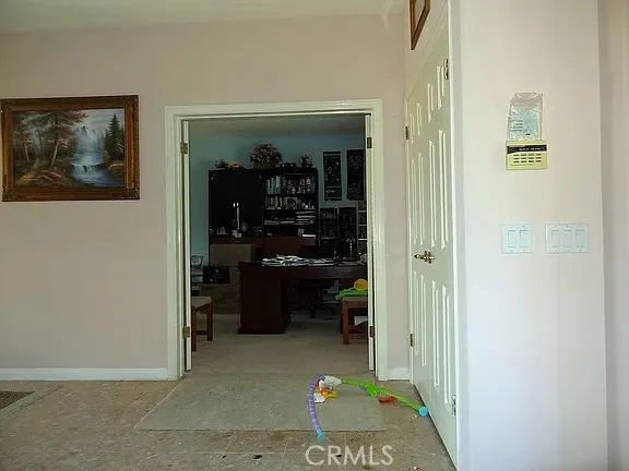 a view of hallway with refrigerator and cabinets