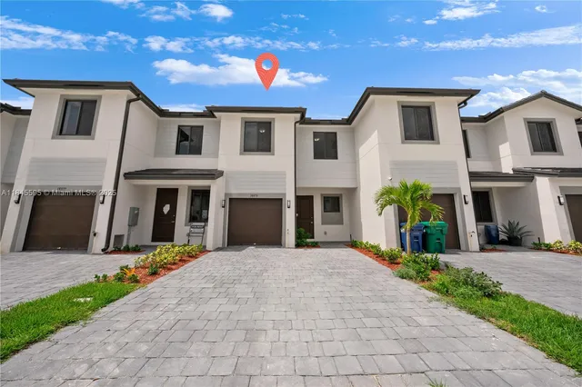 a view of a white house with a small yard