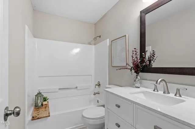 a bathroom with a granite countertop sink a toilet and shower
