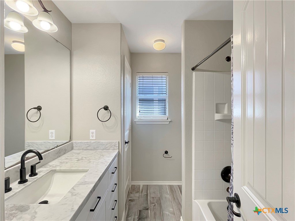 403 Red Hawk Drive Leander, TX 78641 - Photo 12 of 35 a bathroom with a granite countertop sink and a mirror